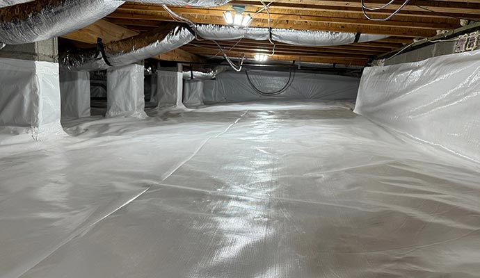 A clean, bright, and professionally encapsulated crawlspace with a white vapor barrier