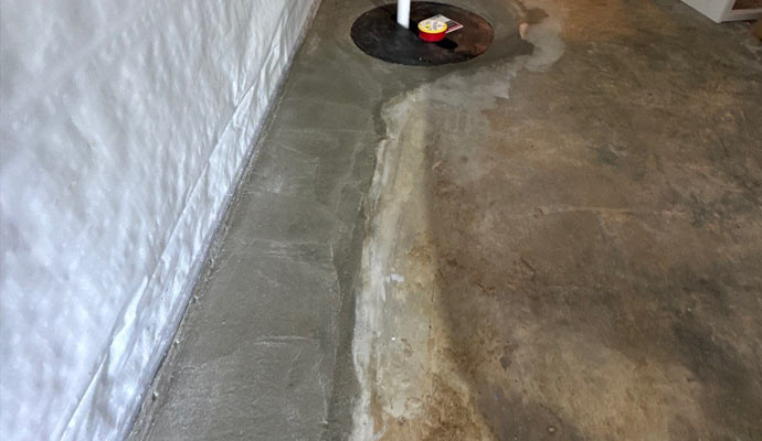 Basement with an interior drainage system installed along the foundation wall